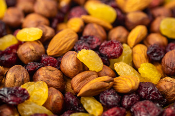 Mix of dried fruits. Healthy snacks. Almonds, raisins, hazelnuts, cranberries. Assorted nuts and dried berries. Selective focus, focus on the front. Healthy food concept