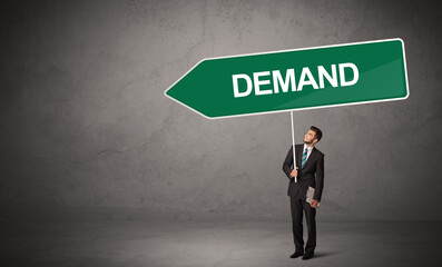 Young business person in casual holding road sign