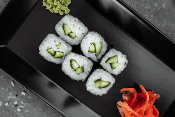 Delicious, juicy and mouth-watering maki with cucumber. Sushi on a gray background