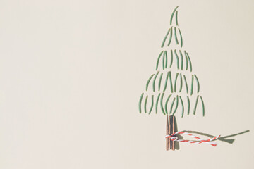 Christmas tree made of pine needles and mashes on pastel yellow background