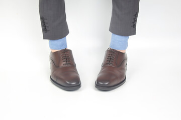 Classic brown shoes worn on the hands on a white background
