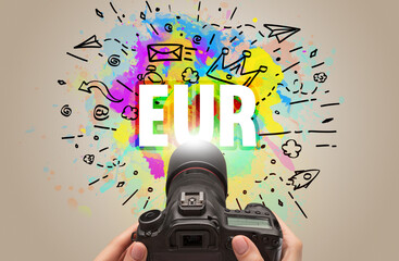 Close-up of a hand holding digital camera with abstract drawing