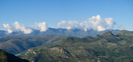 Paisaje panorámico de montañas  y nubes blancas sobre un cielo azul en el Mirador del Soplao en Cantabria, verano de 2020
