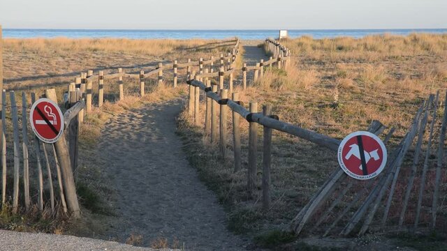 Chemin menant &agrave; la plage du Barcar&egrave;s, Pyr&eacute;n&eacute;es-Orientales, Roussillon, Occitanie. Des barri&egrave;res et des panneaux emp&ecirc;chent le public d'aller pi&eacute;tiner la v&eacute;g&eacute;tation.
