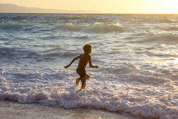 American boy frolics, bathes and swims in the sea. Plays in the spray of sea waves. 