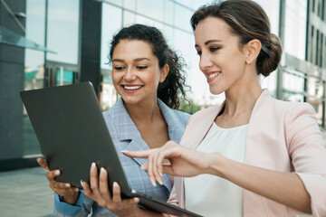 Business, people, tehnology and lifestyle concept: Portrait of two businesswomen looking at laptop