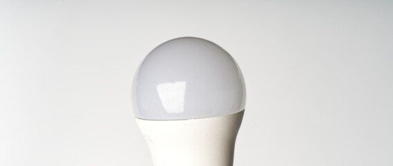 The upper part of an energy-saving light bulb on a white background.