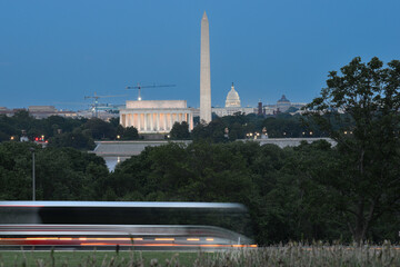 Tour buses in motion blur with Washington DC skyline at night background - Washington DC United...