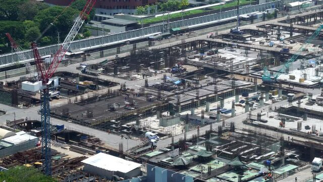 Large construction site with heavy construction machinery in metropolis captured during the early stage of mega construction project .