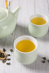 green tea with tea cups and teapot  on wooden table