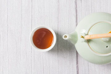 black tea with tea cups and teapot, with green leaves. 