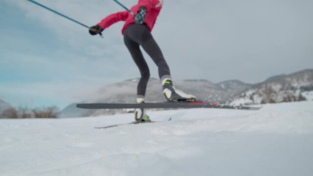 SLOW MOTION, CLOSE UP, LOW ANGLE, DOF: Cinematic shot of a female athlete during intense nordic ski training in the Slovenian mountains. Young woman prepares for the Olympic trials in Nordic skiing.