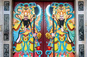 Decorative paintings on a door at a Buddhist temple in Kanchanaburi Thailand