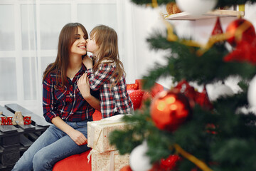 Mother with cute daughter at home with christmas gifts