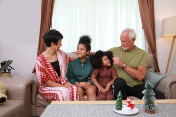 Parent and daughter site together on sofa in living room, happy family and caring concpet