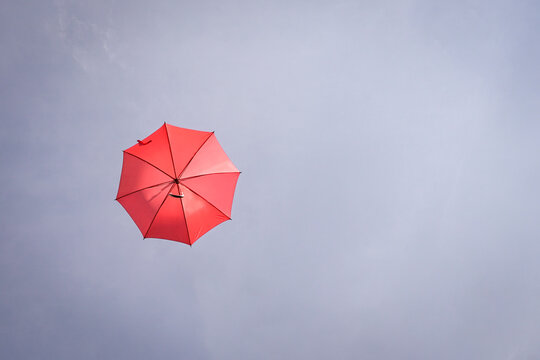Red umbrella on blue sky. Copy space.