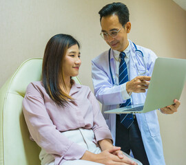 doctor man explain health care result on laptop to patient woman in hospital