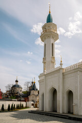 Fototapeta na wymiar View of the minaret of the Irek Mosque on Fedossevskaya Street and the Church of the Holy Great Martyr Evdokia in the background, Kazan, Republic of Tatarstan, Russia