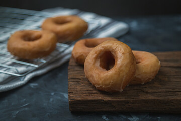 donuts on old wooden cutting board on dark background