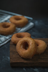 donuts on old wooden cutting board on dark background