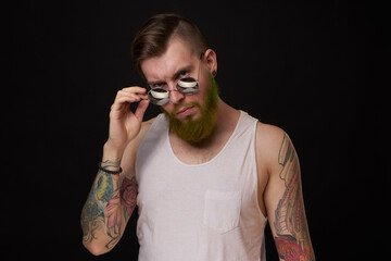 bearded man in white t-shirt with tattoos on his arms posing macho