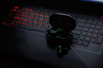 laptop keyboard with Bluetooth earphones  
