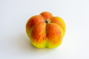 An interesting, unusual, strange apple. An ugly apple surrounded by ordinary ones. The photo...