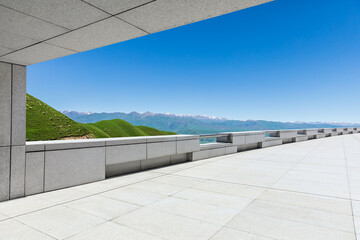 Empty square floor and mountains under blue sky