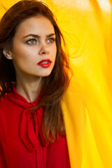 cheerful woman in red dress makeup yellow cloth posing