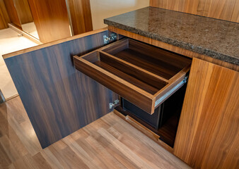 An open wooden drawer in a storage cabinet.