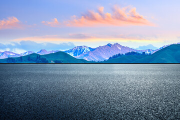 Empty asphalt road and mountain scenery at sunrise