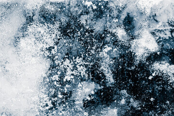 Ice texture background. The textured cold frosty surface of ice block on dark background.