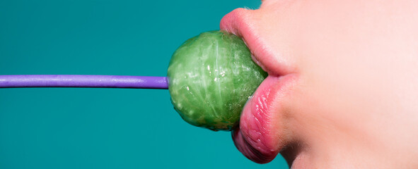 Close up profile, model sucking a green lollipop