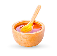 Honey dripping from honey dipper in wooden bowl on white background.