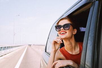 Naklejka premium a woman is driving in a car on the road and looking out of the window