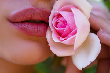 Lips with rose closeup. Pink lips. Natural paint from the lips. Sensual lips on beautiful model...