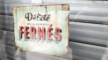 Fototapeta premium desole nous sommes ferme french text means sorry we are closed sign board vintage board on windows shop restaurant cafe store signboard