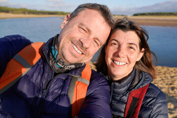 cheerful happy couple taking selfie in vacation on sand beach sea