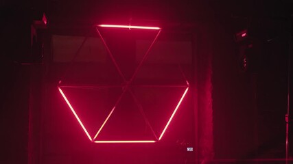 flashing lights of purple tube lamps in shape of hexagon on brick wall with bright laser spotlights. underground rave party at abandoned warehouse. youth leisure, nightlife, hip hop, music concert