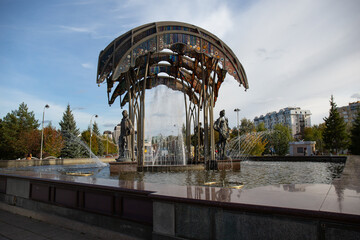 A beautiful fountain with sculptures on the central square of the city of Tyumen in autumn