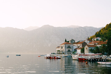 Fototapeta na wymiar Boats on the pier of Perast against the background of mountains. Montenegro