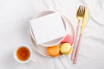 Plate with Mockup paper blank and macarons on textile background