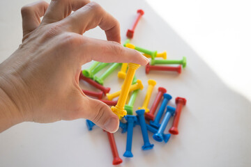 He holds a lot of colorful plastic parts of the designer in his hands. Rainbow elements in the hands. Choosing a future profession for a child. Methods of early child development