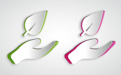 Paper cut Hand hold a leaf of the plant icon isolated on grey background. Care nature. Leaf shoots with environmental protection. Paper art style. Vector