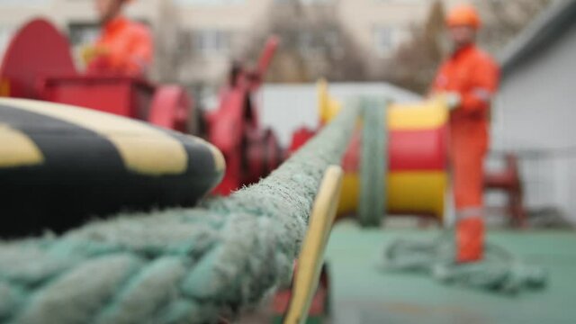 Sturdy nylon sling stowing and going from a bollard to a  worker with a wrinch. 