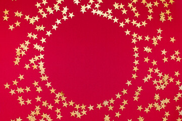 Golden confetti stars form a round frame with space for text on red