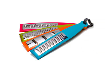 Various multicolored vegetable graters on a white isolated background. Kitchenware.