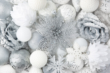 Christmas decor. White and silver colors. Monochrome. Christmas balls, decorations on a white background. Top view. Space for text.