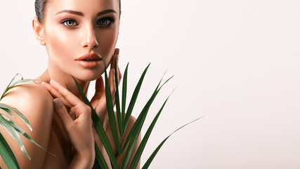Young beautiful woman with green leaves near body. Skin care beauty treatments concept.  Closeup...