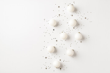 Top view photo of white christmas tree decorations balls and silver confetti on isolated white background with copyspace